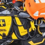 Přilba, záchranný batoh a prostředky osobní ochrany proti pádu připravené ke kontrole