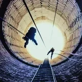Dva průmysloví lezci na lanech uvnitř cihlového komína